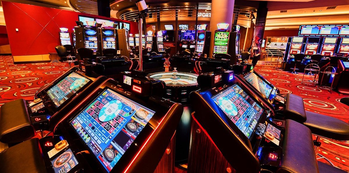 Photo of many slot machines inside a casino with carpet on the floor and elegant decoration