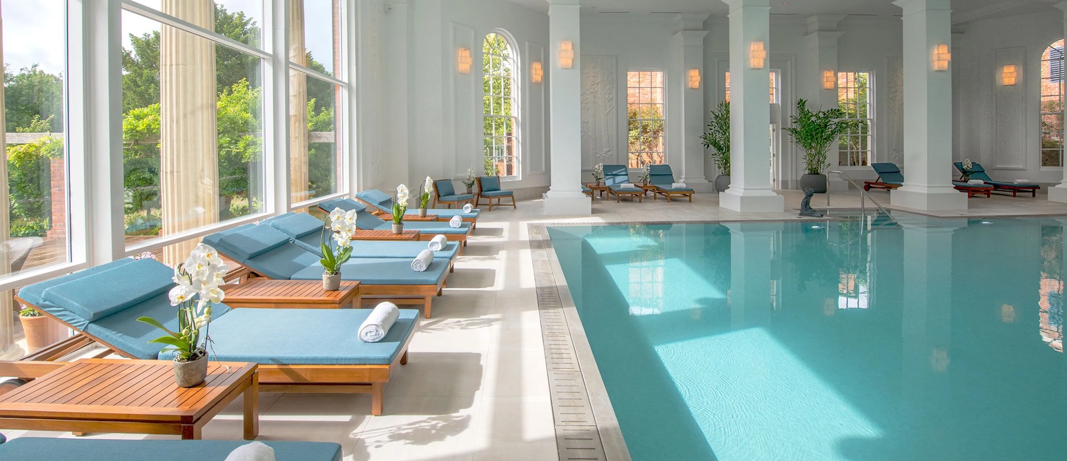 A woman relaxing inside a heated pool at a spa and wellness center