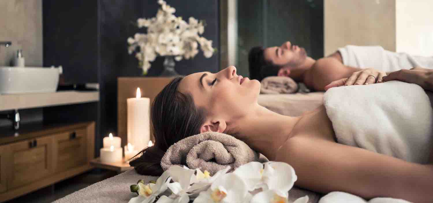 A couple lying down while having a beauty and massage treatment